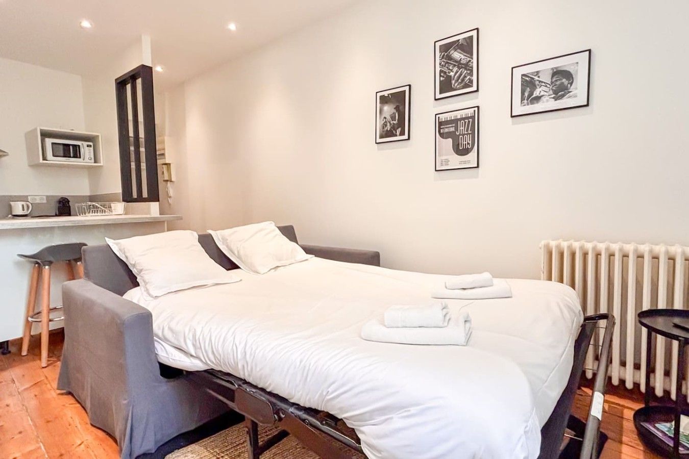 Une chambre d’hôtel avec un lit, un bureau doté d’un micro-ondes et des tableaux accrochés au mur.