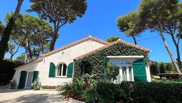 Un edificio con facciata bianca, persiane verdi e tetto a tegole.