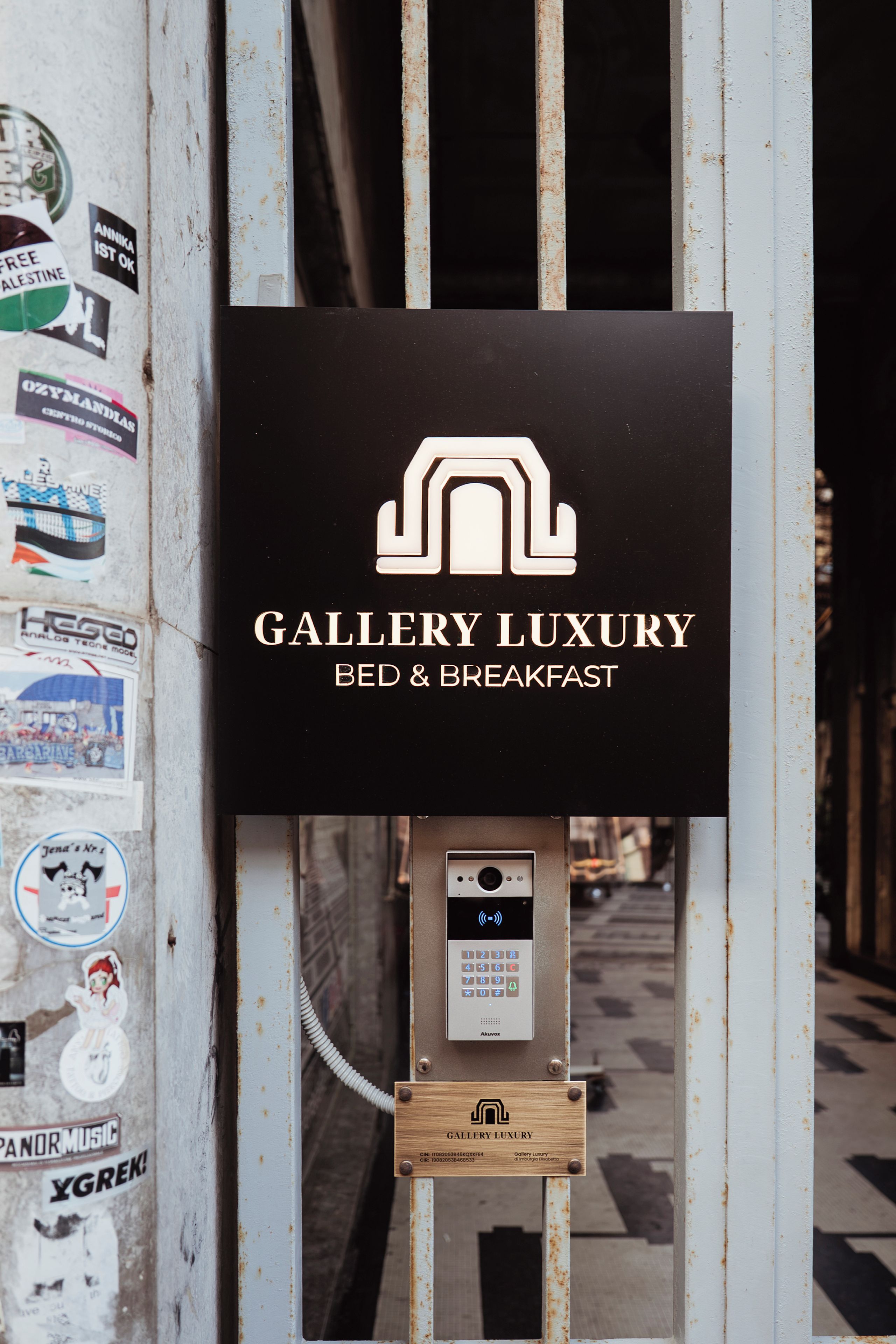 Un letrero que dice 'Gallery Luxury Bed & Breakfast', con un teclado y una placa de madera debajo.