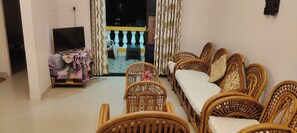 A living room with a sofa set, a television, and a table with a floral tablecloth. - Reliance sea mist (Morgoa)