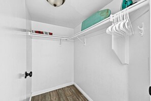 Ein Schrank mit weißen Wänden, Holzboden und einer Deckenleuchte.