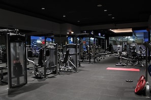 Un gimnasio con diversos equipos de ejercicio, incluyendo máquinas de pesas y pesas libres.