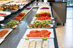 Buffet amb plats variats, com ara amanides, verdures i formatge.