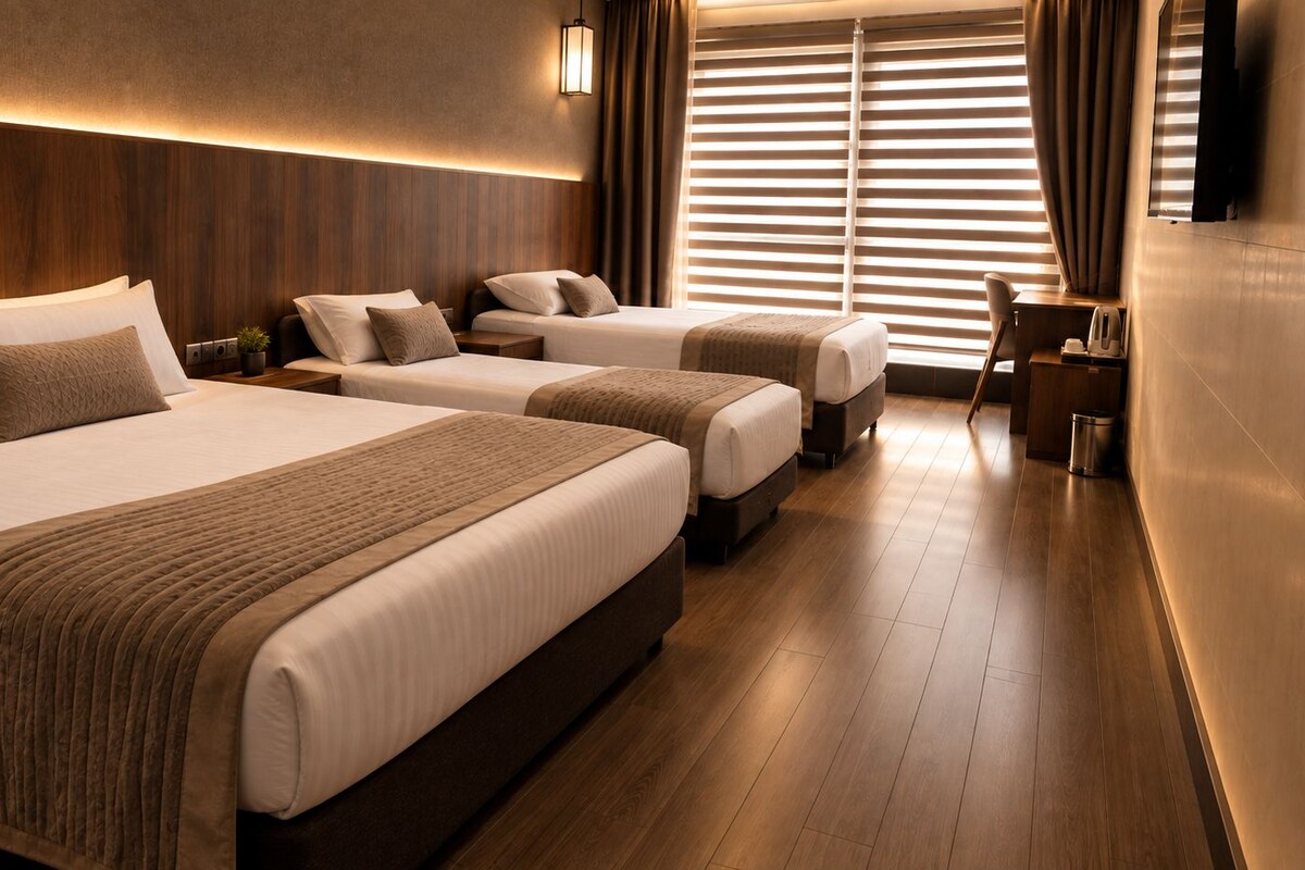 Habitació d'hotel amb dos llits, un escriptori i una cadira.