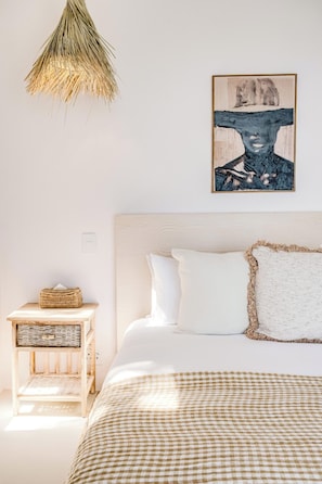A bedroom with a bed, a bedside table, a hanging light fixture, and a wall-mounted artwork. - Camps Bay 6 Bed Ocean Views and Pool Villa Kai (Cape Town)