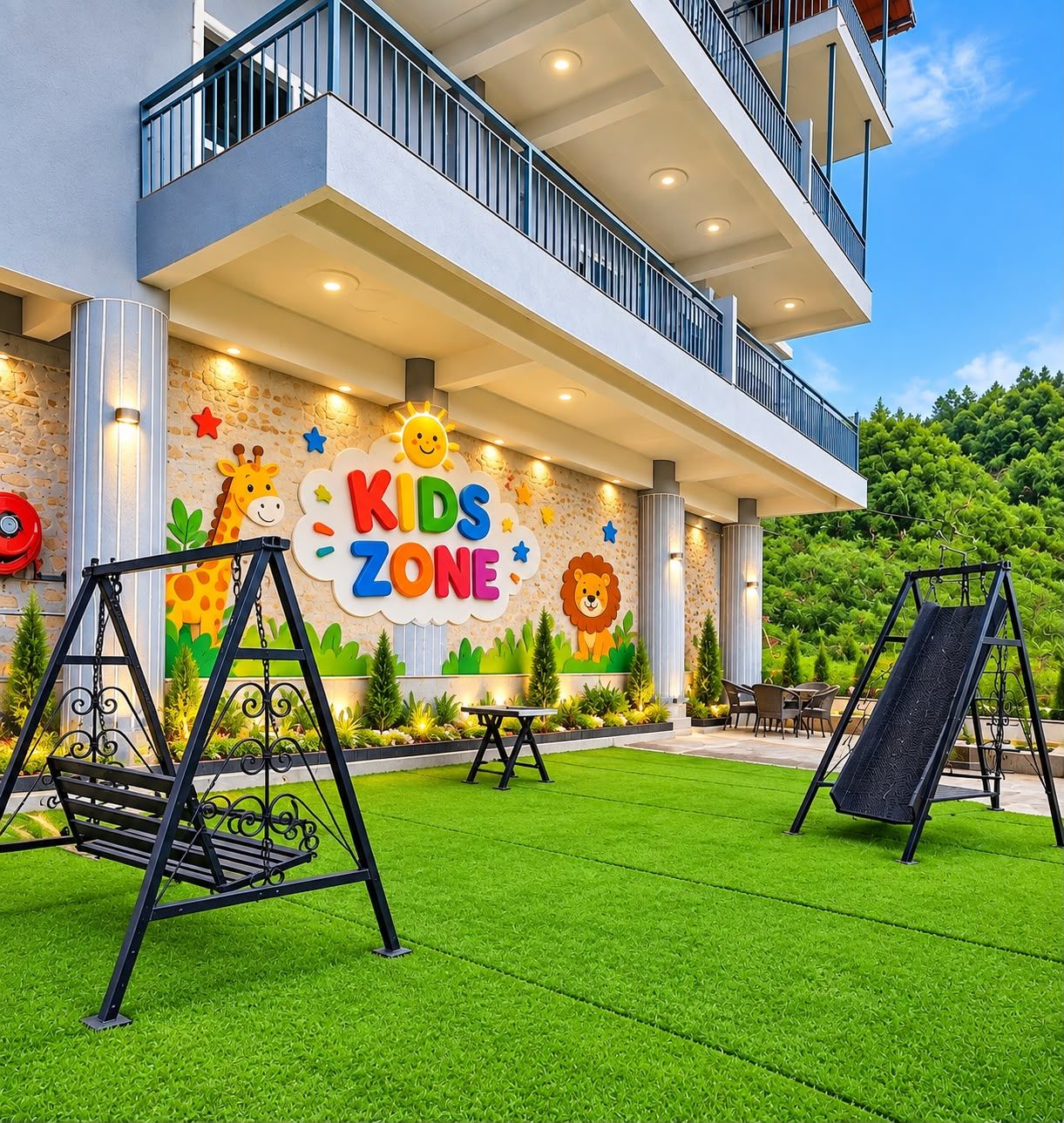 Un edificio moderno con una zona de juegos infantiles que incluye columpios y un tobogán, un mural con personajes de animales y un balcón con vistas a un césped verde.