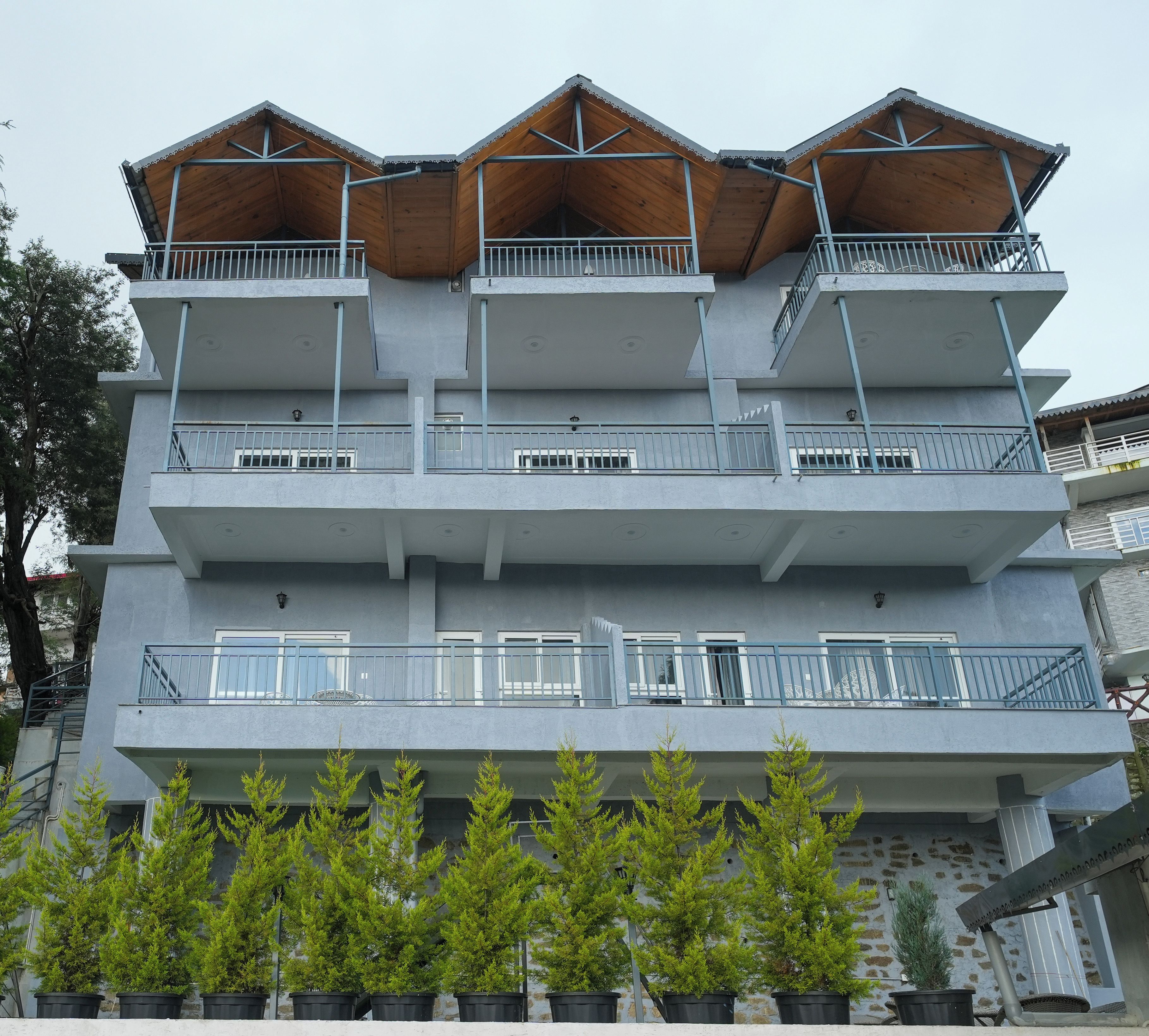 A multi-story building with balconies, staircases, and potted plants.