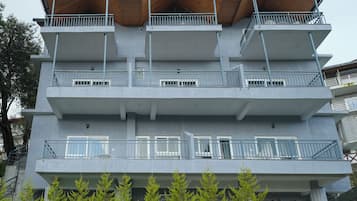 A multi-story building with balconies, staircases, and potted plants.