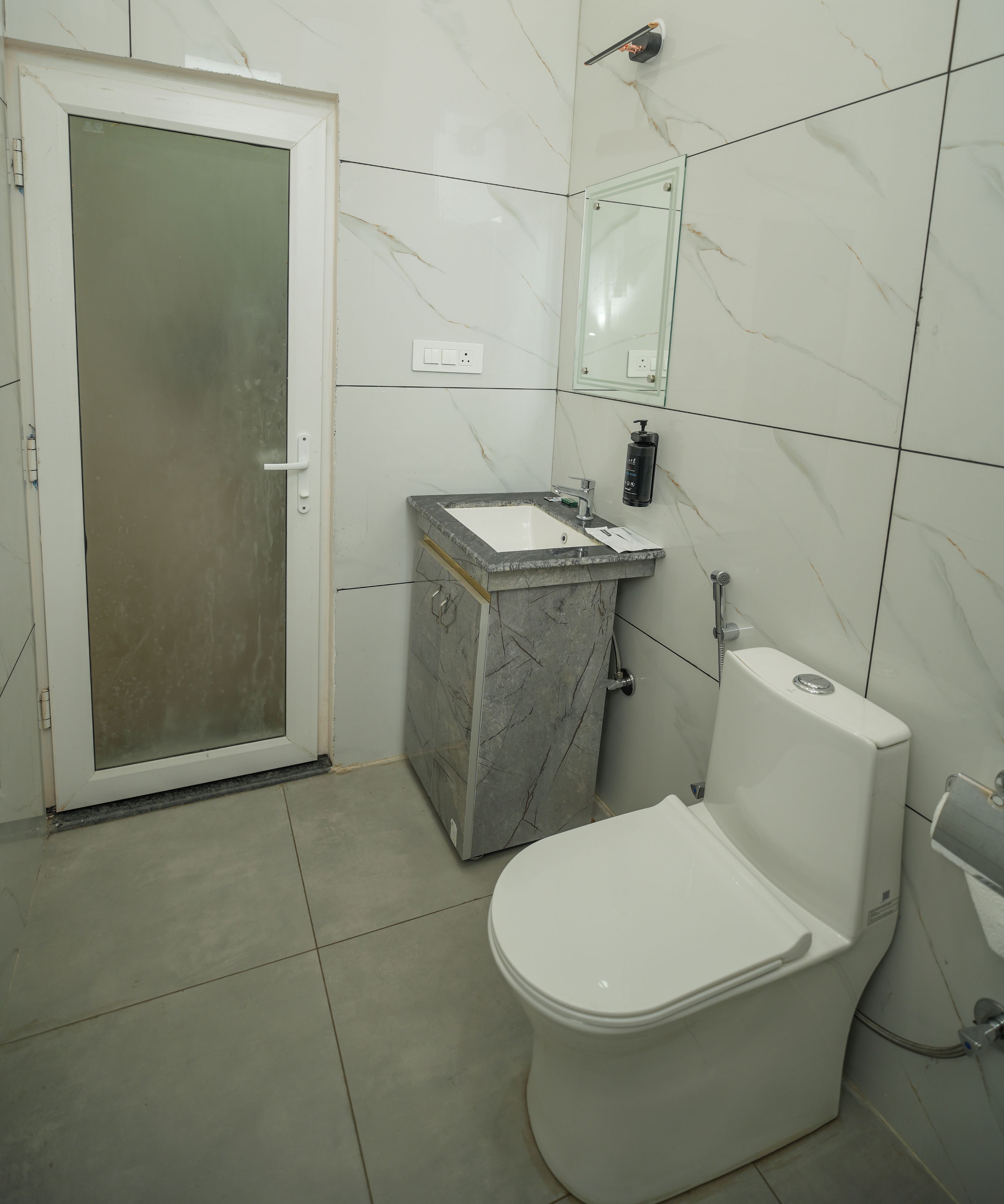 A bathroom with a toilet, sink, and shower.