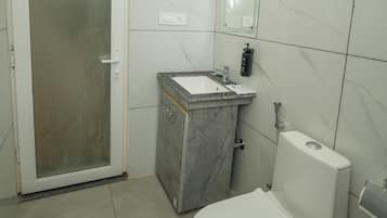 A bathroom with a toilet, sink, and shower.