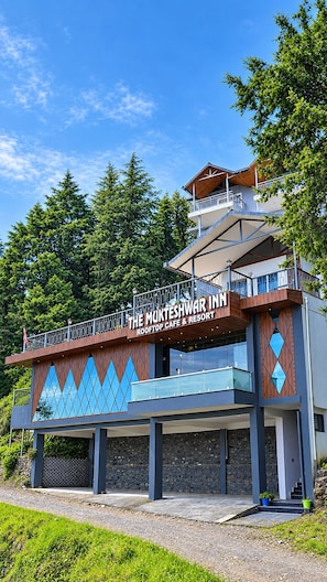 A building with a sign reading 'The Mukteshwar Inn Rooftop Cafe & Resort'.