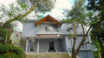 A two-story building with a sign for 'The Mukteshwari Inn Rooftop Cafe & Resort'.