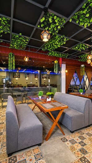 A modern lounge area with seating, a coffee table, and decorative plants.