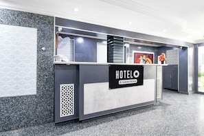A hotel reception desk with a sign indicating it is company-serviced. - Hotel O Raipur formerly Hotel Okasu (Raipur)