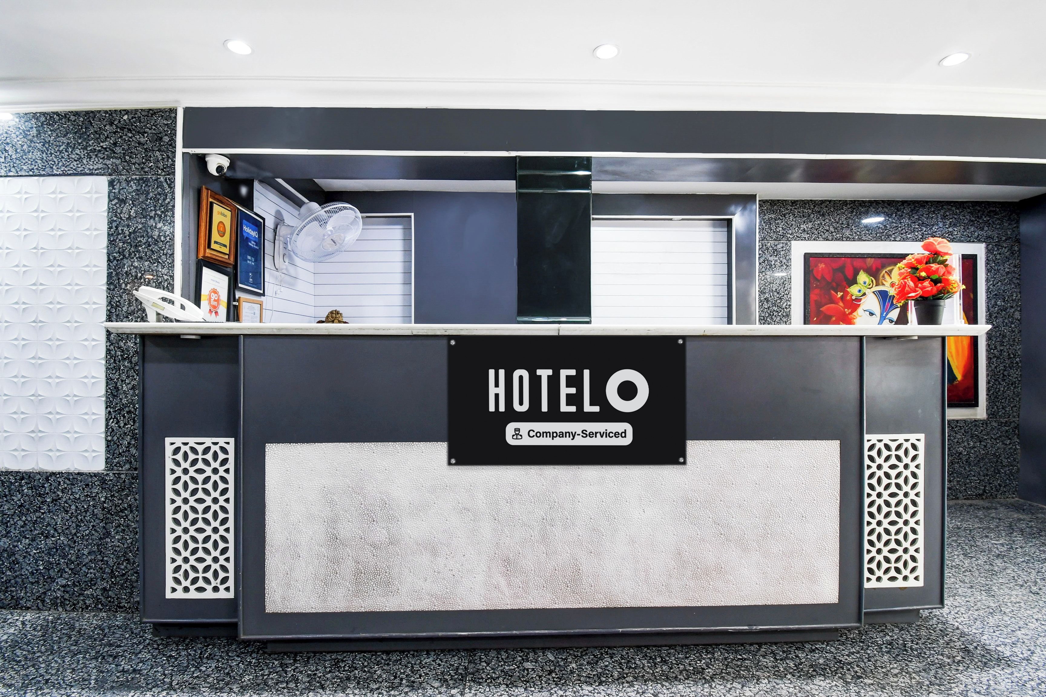 Mostrador de recepción de hotel con un cartel que indica servicio empresarial.