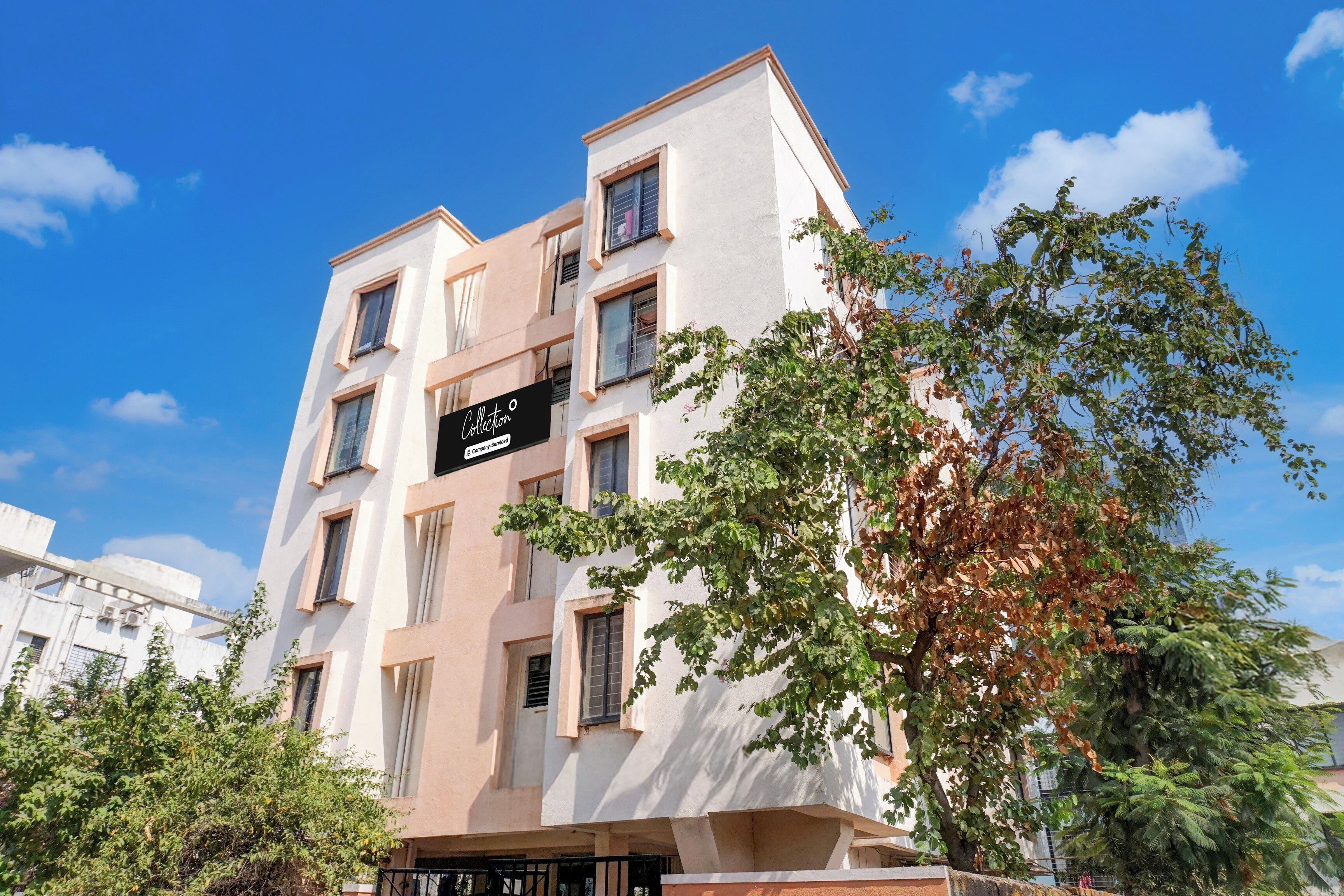 A multi-story building with a sign that reads 'Collection Company-Serviced Apartments.'