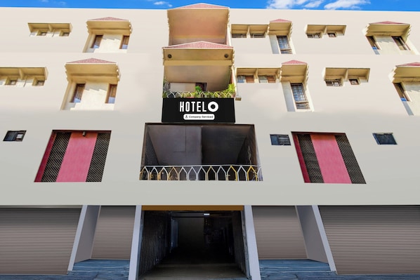 A hotel with a central entrance, multiple balconies, and a sign indicating it is a company-serviced hotel. - Hotel O Paradise Circle (Hyderabad)