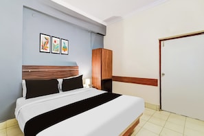 A hotel room with a bed, a wardrobe, and a door. - Hotel O Paradise Circle (Hyderabad)