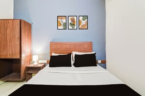 A hotel room with a bed, a nightstand, a lamp, and a wardrobe. - Hotel O Paradise Circle (Hyderabad)