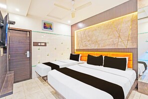 A hotel room with two beds, a ceiling fan, a TV, and a decorative wall panel. - Collection O Chidambaram Stadium (Chennai)