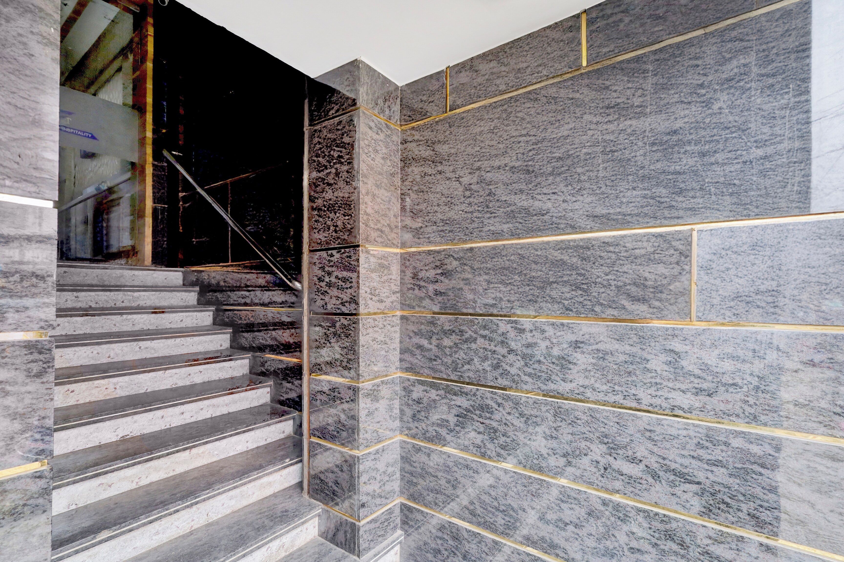 A staircase with a modern design, featuring a combination of marble and stone tiles.