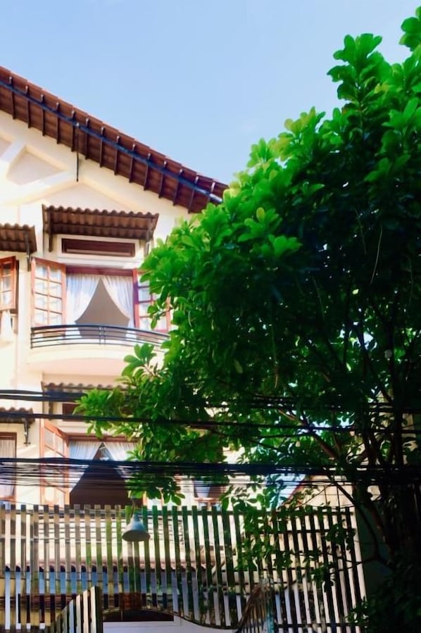 A building with a balcony, a tree in front, and a fence. - Ruhome Quy Nhon - Central & Near Beach (Quy Nhon)