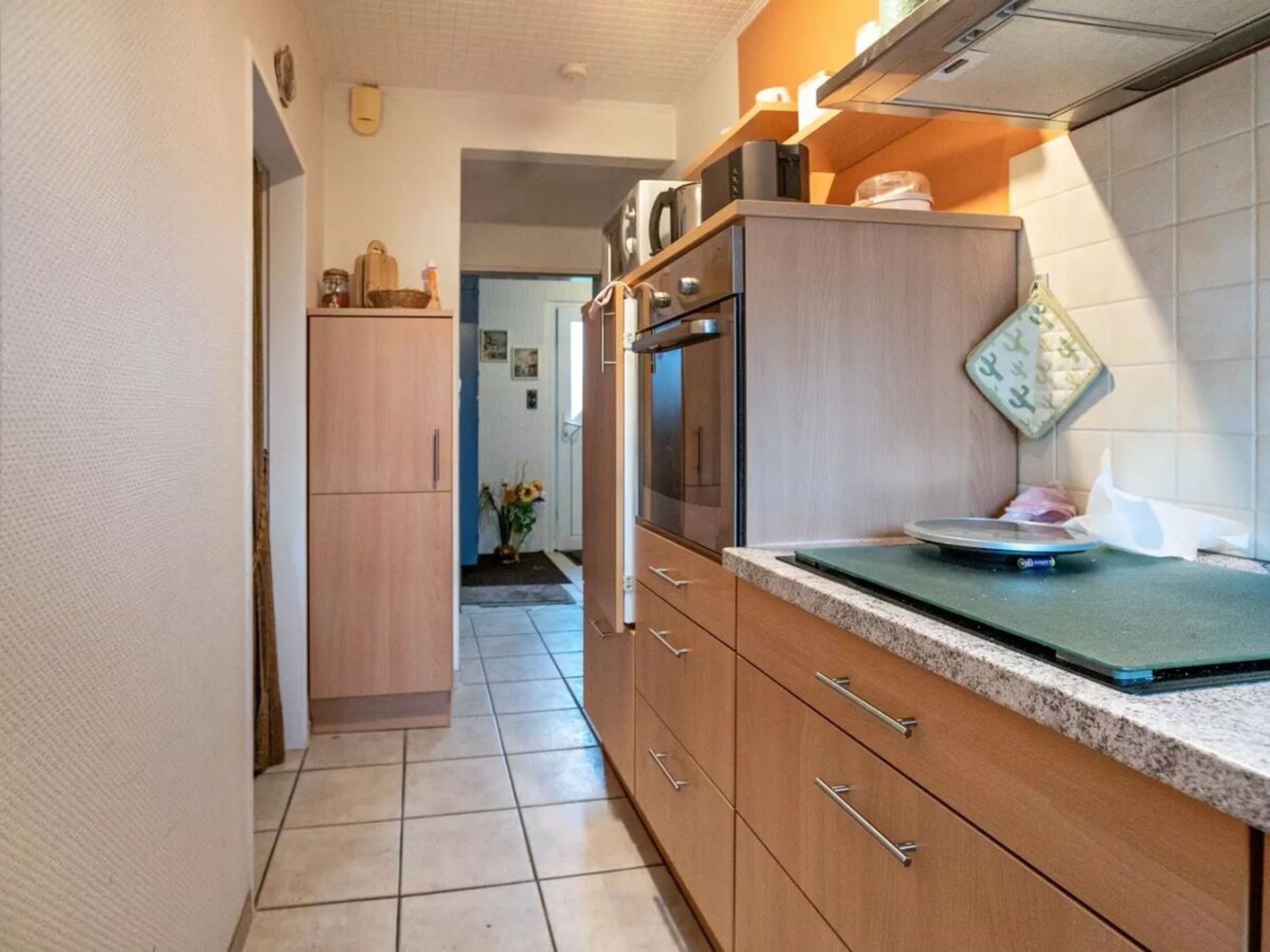 A kitchen with wooden cabinets, a countertop, and a stove.