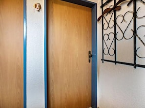 A wooden door with a blue trim and a metal gate on the right side. - Niedl App Helene 2 (Dornum)