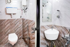 Une salle de bain avec des toilettes, un lavabo et une douche.