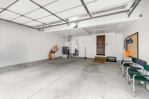 A spacious indoor area with a high ceiling, a door, and a bench with a sign.