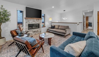 A living room with a fireplace, a sofa, a chair, and a coffee table.