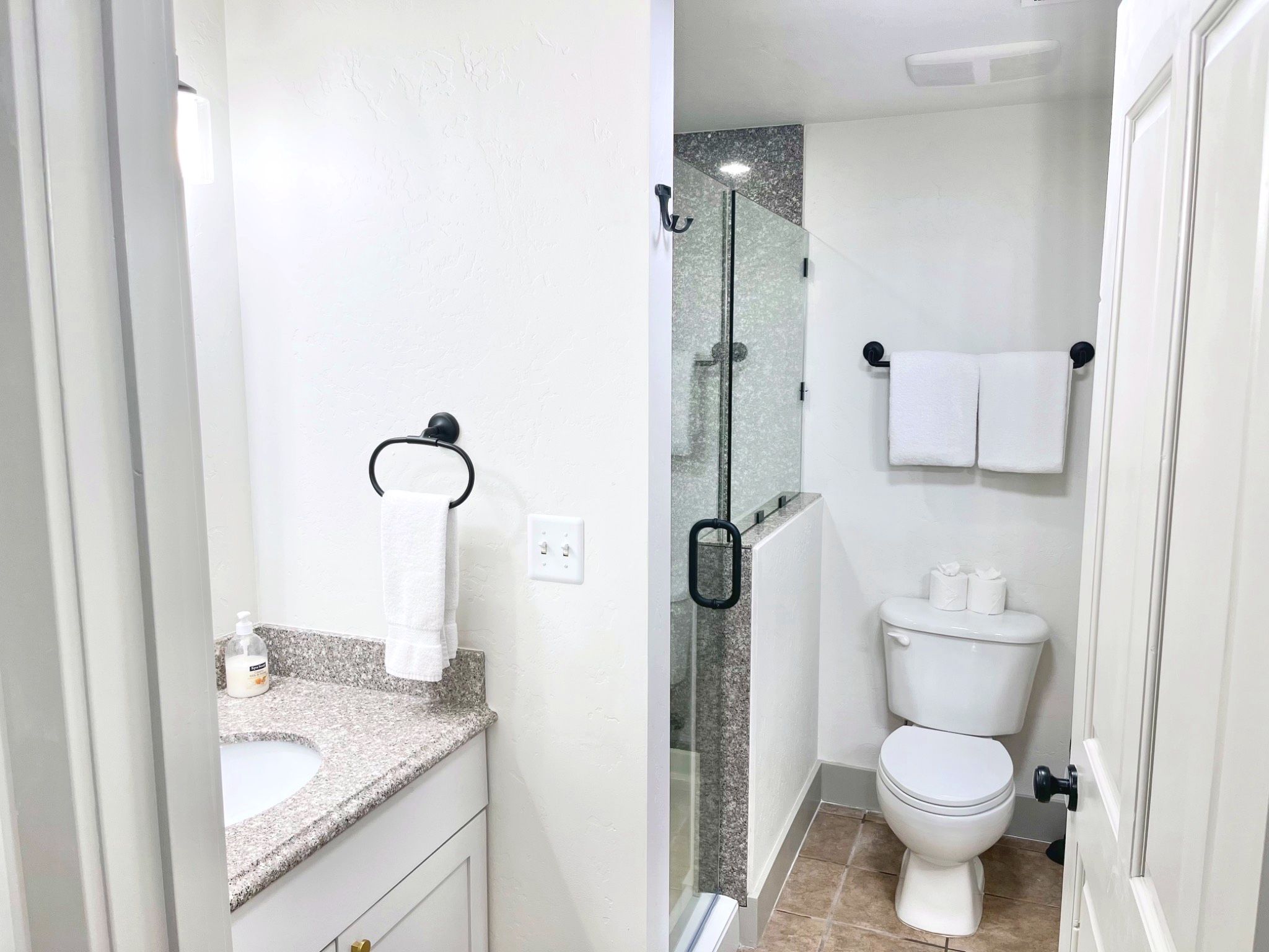 A bathroom with a toilet, sink, and shower.