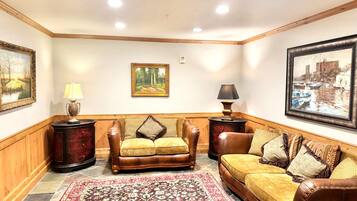 A living room with a brown leather sofa, a patterned rug, and two side tables with lamps.