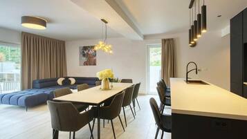 Una sala de estar moderna con un sofá, una mesa de comedor y sillas.