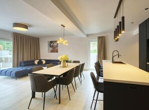 Ein modernes Wohnzimmer mit einer Couch, einem Esstisch und Stühlen.