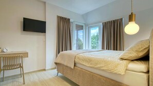 A bedroom with a bed, a desk, a chair, a television, and a window with curtains. - Villa One (Jastrebarsko)