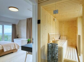 Habitación de hotel moderna con una cama grande, un escritorio y vistas al exterior.