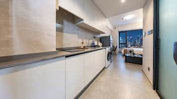 Una cocina moderna con horno empotrado, lavadora y un amplio ventanal con vistas a la ciudad.
