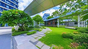 A modern building with a covered walkway, green lawns, and a variety of plants. - ruilantingyuan (shenzhen)