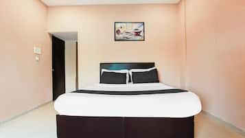 Un dormitorio con cama, una puerta y un cuadro en la pared.