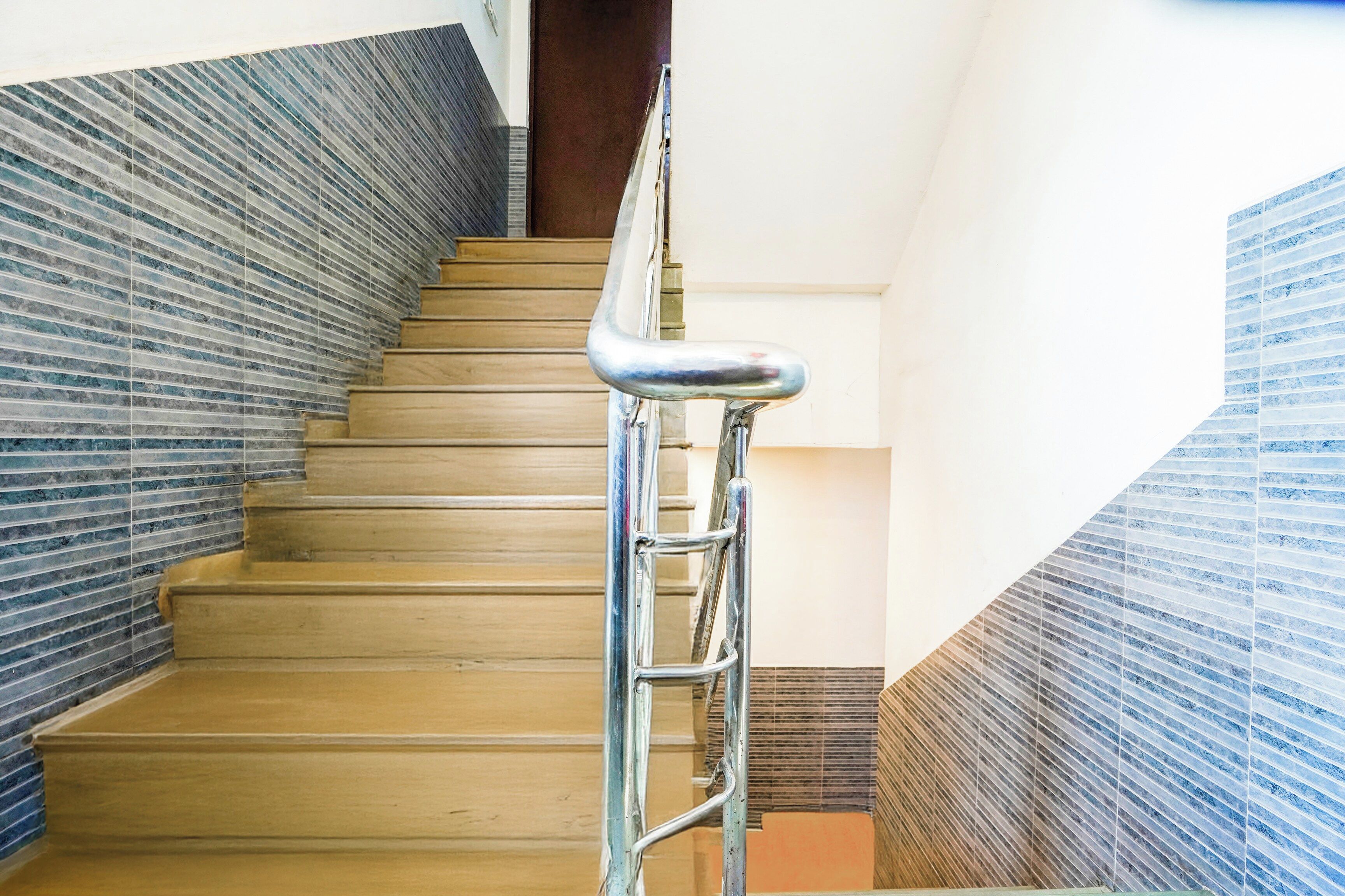 A staircase with a metal handrail and wooden steps.