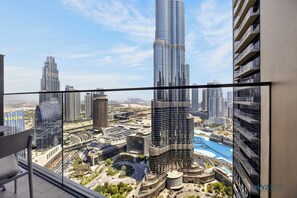 A high-rise building with a view of a cityscape, including other tall buildings and a roundabout. - Address Opera 3BR Burj Khalifa View (Dubai)