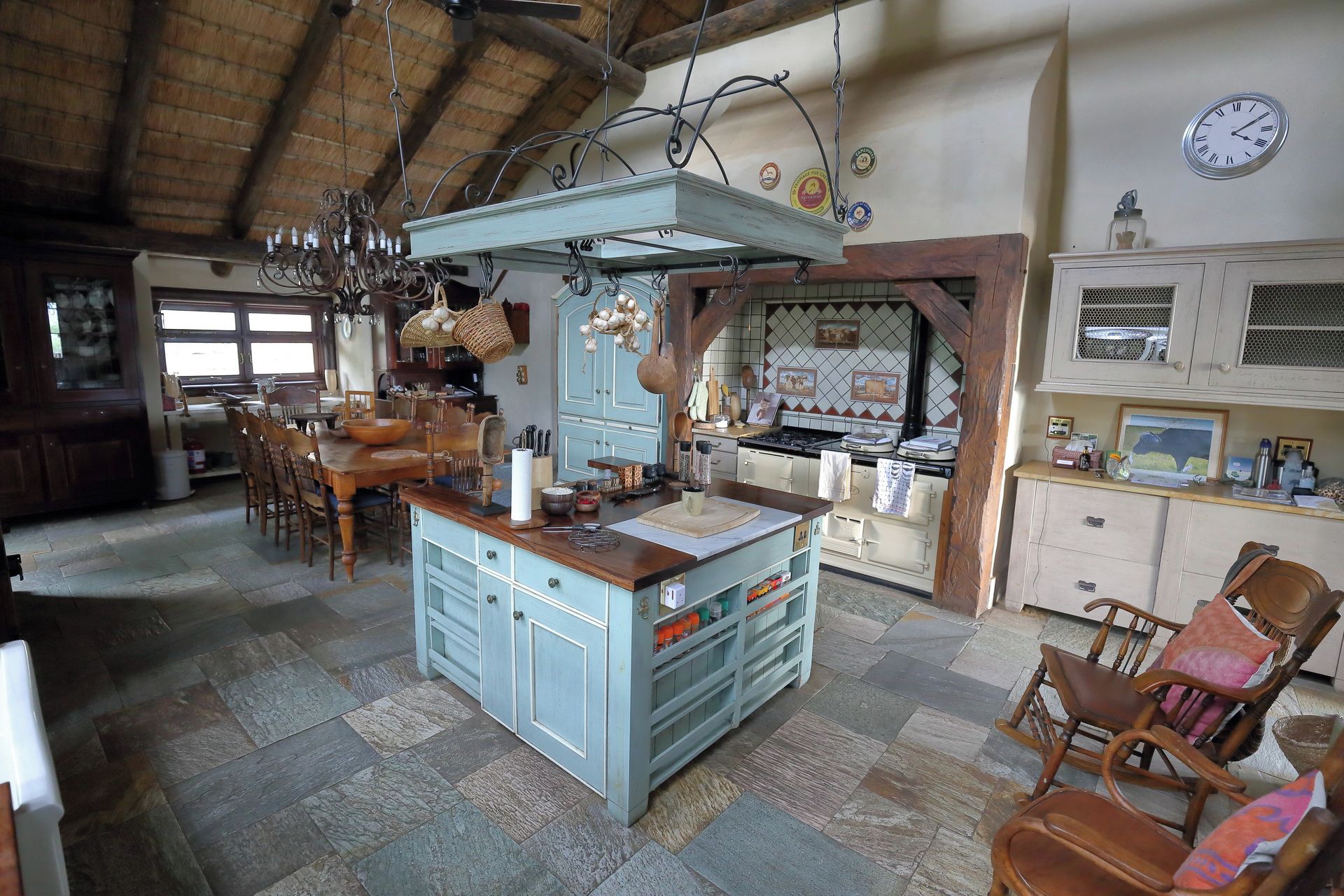 Une cuisine rustique avec un îlot central, des chaises en bois et une table à manger.