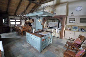 Une cuisine rustique avec un îlot central, des chaises en bois et une table à manger.