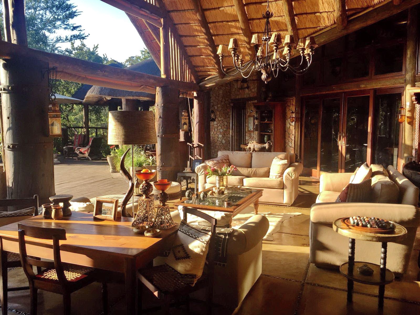 Un salon confortable avec un plafond en bois, un ensemble de canapés, une table basse et un lustre.