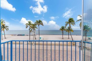 Blick auf einen Strand mit Palmen und blauem Himmel.