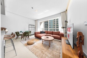 En moderne stue med sofa, sofabord og spiseområde.