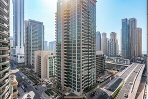 A high-rise building with multiple balconies, surrounded by other tall buildings, in a cityscape. - StayShort - Chic 1 Bedroom Haven Perfect for 2 in Dubai Marina! (Dubai Marina)