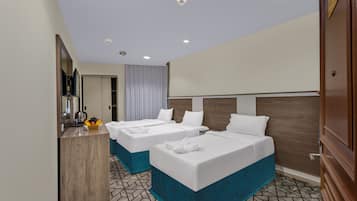 Habitación de hotel con dos camas, un escritorio, un espejo y la puerta del baño.