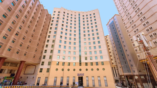 A multi-story hotel with a central entrance, numerous windows, and a modern architectural design. - ADDRESS AJYAD HOTEL (makkah)